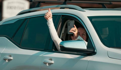 Happy buddii customer giving a thumbs up from their new car