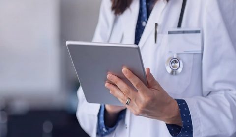 Doctor checking a roster on a tablet