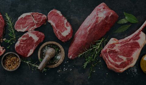 Premium cuts of meat on a dark slate board